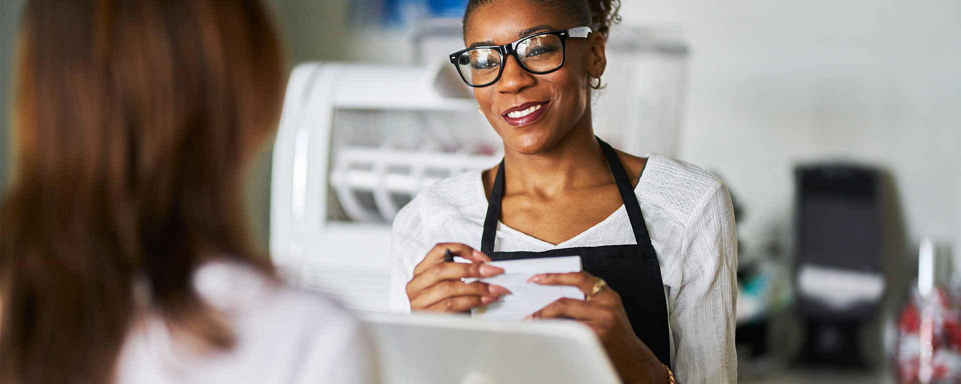 Small business owner standing at cash register